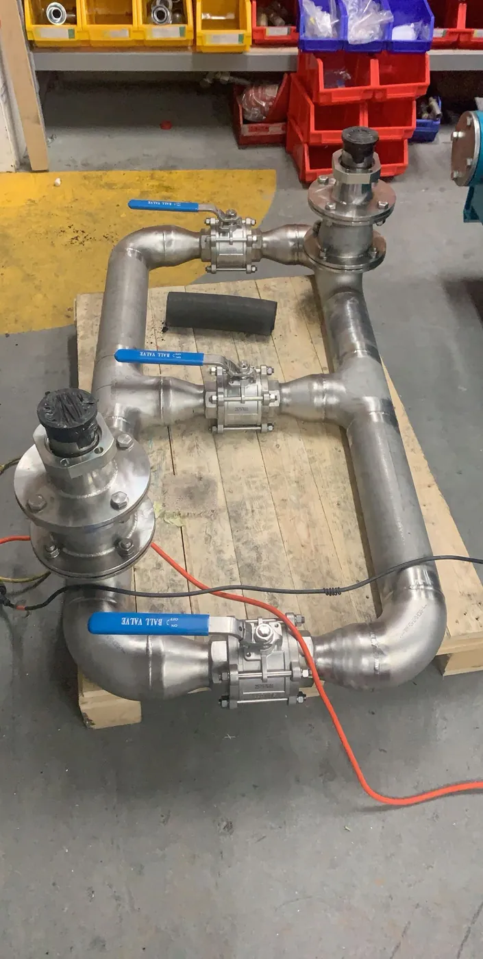 A stainless steel manifold with three ball valves